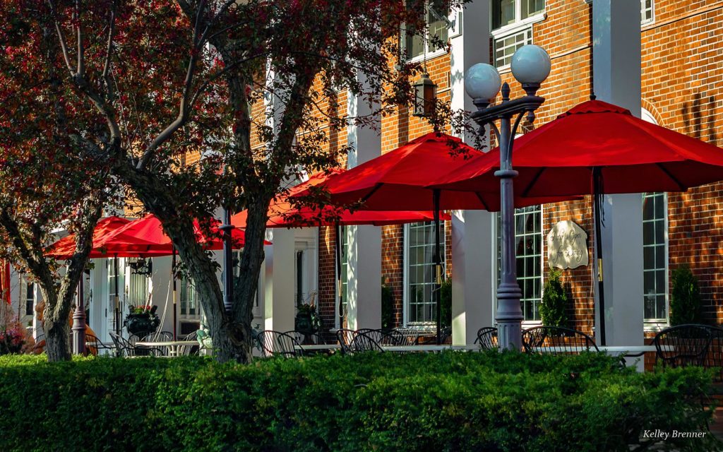 Front dining patio with red umbrellas at historic Lowell Inn in downtown Stillwater Minnesota